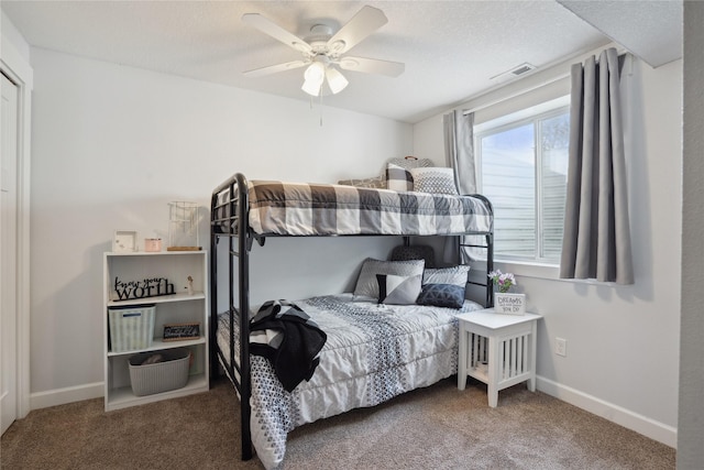 carpeted bedroom with a ceiling fan, baseboards, visible vents, and a textured ceiling