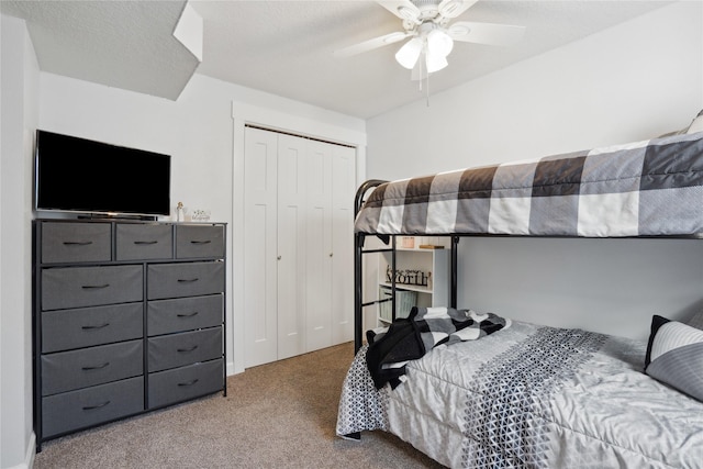 bedroom with a textured ceiling, a closet, carpet, and a ceiling fan