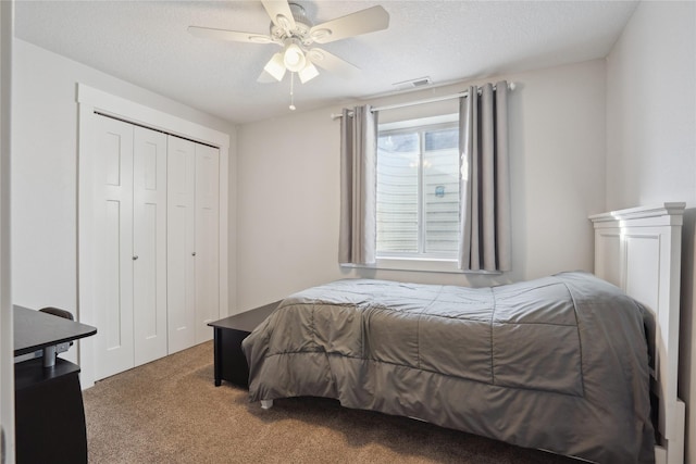 bedroom with a textured ceiling, a closet, carpet, and visible vents