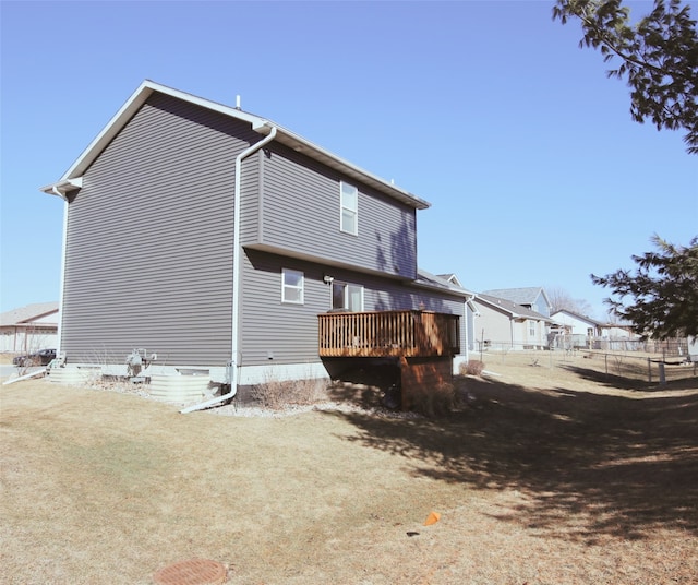 rear view of property with fence and a deck