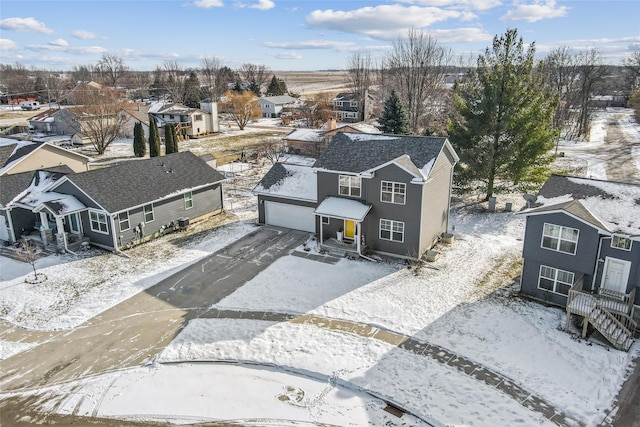 snowy aerial view with a residential view