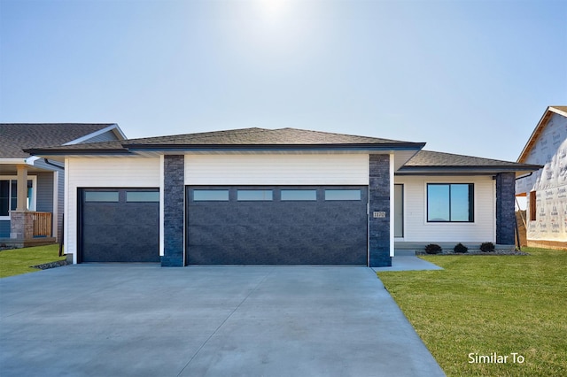 prairie-style house featuring an attached garage, driveway, a shingled roof, and a front yard