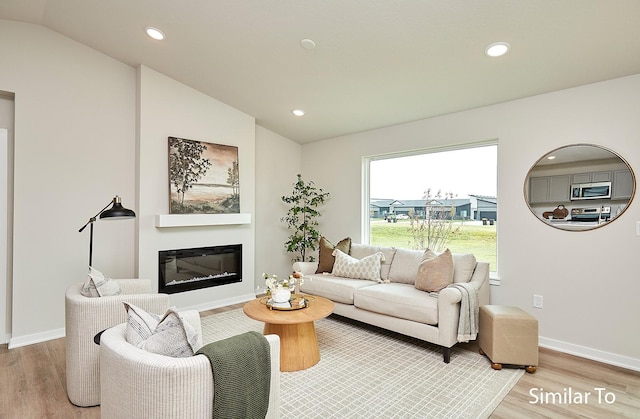living room featuring recessed lighting, light wood-style floors, and lofted ceiling