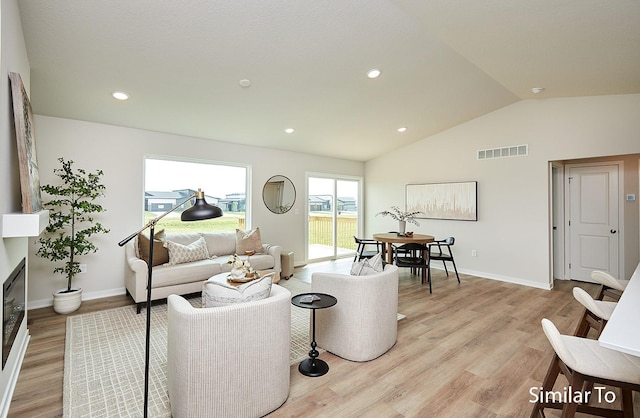 living area featuring vaulted ceiling, baseboards, visible vents, recessed lighting, and light wood-style floors