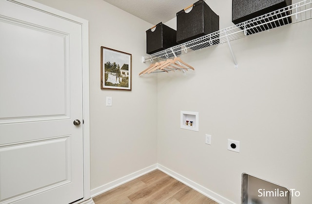 clothes washing area with laundry area, light wood-style floors, baseboards, electric dryer hookup, and washer hookup