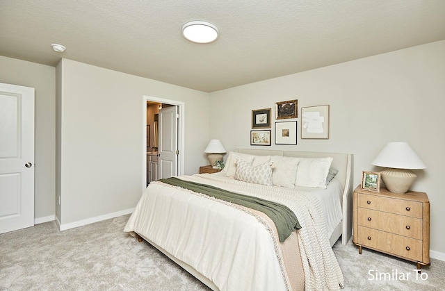 bedroom featuring carpet flooring, a textured ceiling, baseboards, and ensuite bathroom