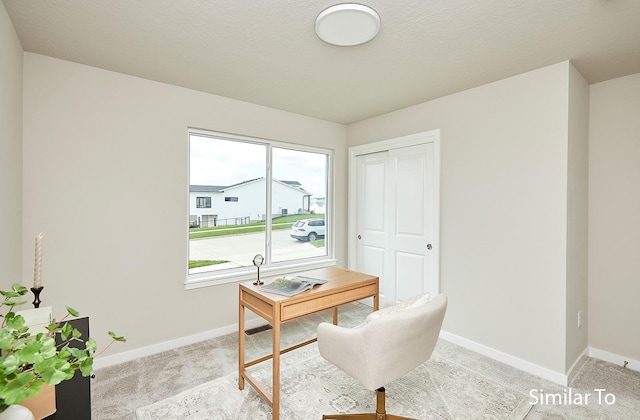 office with baseboards and light colored carpet