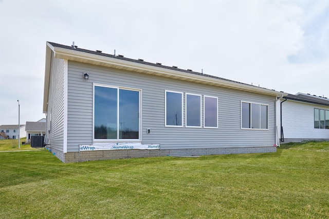 back of property featuring a lawn and cooling unit