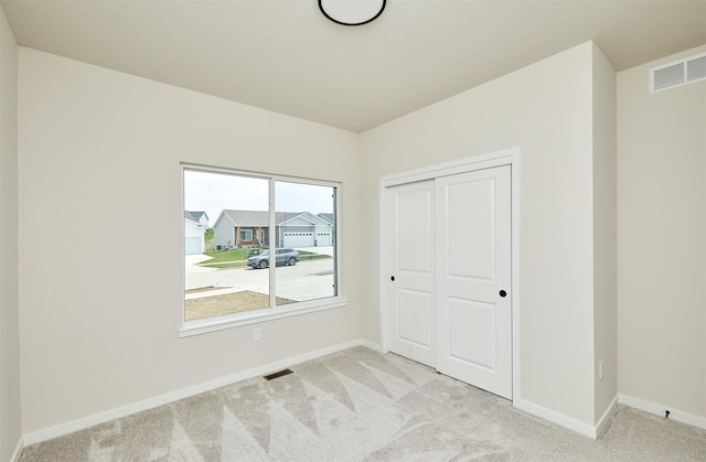 unfurnished bedroom featuring carpet floors, visible vents, and baseboards