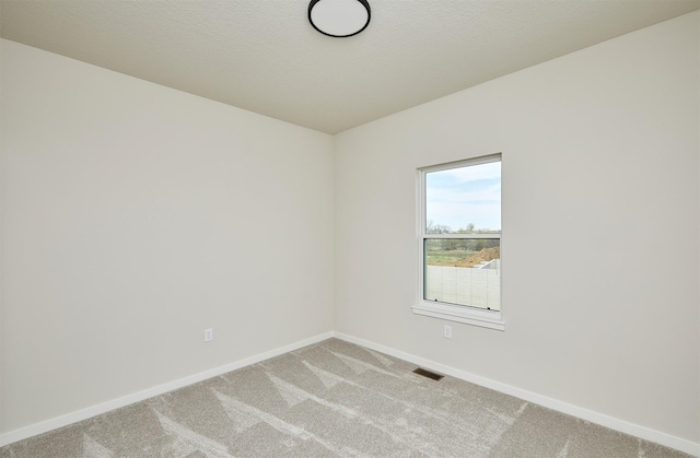 unfurnished room with visible vents, baseboards, and light carpet