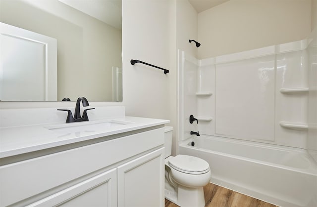full bath with shower / washtub combination, toilet, vanity, and wood finished floors