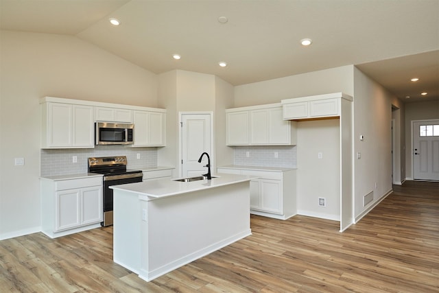 kitchen featuring light wood-style flooring, a sink, white cabinetry, and appliances with stainless steel finishes