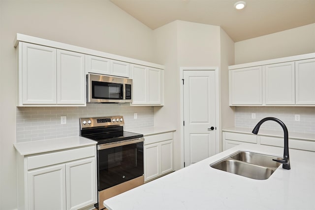 kitchen featuring light countertops, backsplash, appliances with stainless steel finishes, and a sink