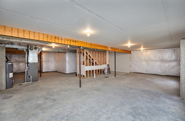 unfinished basement with heating unit and electric water heater