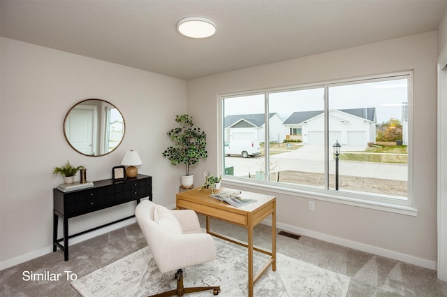 office area with carpet flooring, visible vents, and baseboards