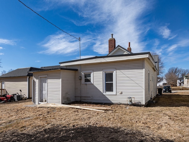 rear view of house featuring a chimney