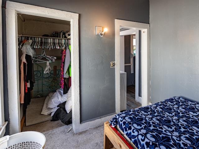 carpeted bedroom featuring a closet and washer / dryer