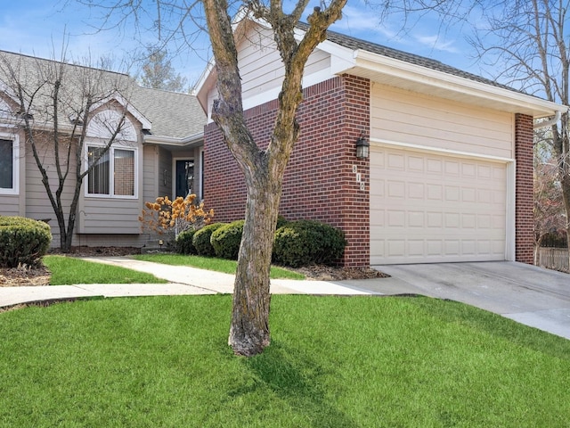 view of side of home with driveway, a yard, an attached garage, and brick siding