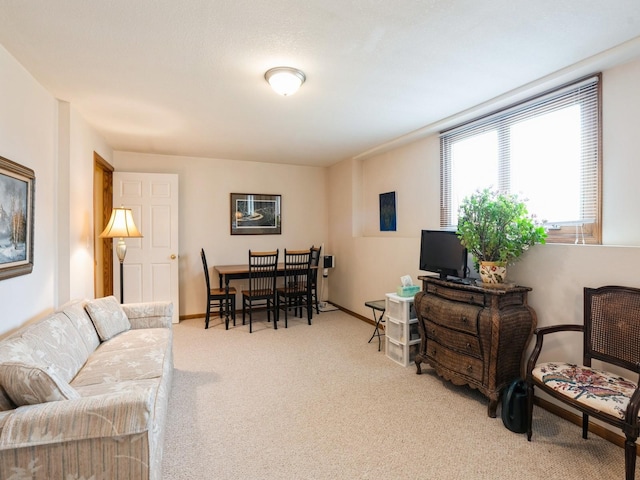 carpeted living area featuring baseboards