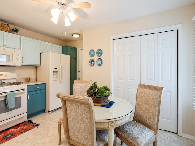 kitchen with light tile patterned floors, white appliances, a ceiling fan, light countertops, and blue cabinetry