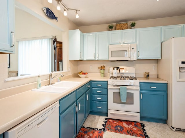 kitchen featuring white appliances, light countertops, blue cabinetry, a sink, and light tile patterned flooring