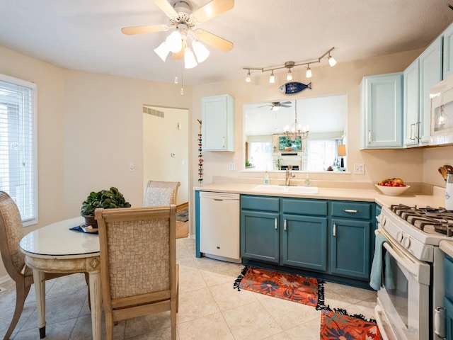 kitchen featuring light countertops, a sink, blue cabinets, white appliances, and ceiling fan with notable chandelier