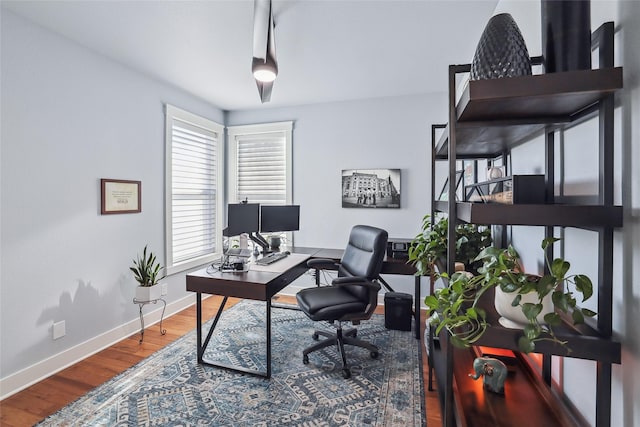 office area with baseboards and wood finished floors