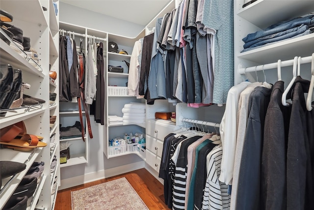 walk in closet with wood finished floors