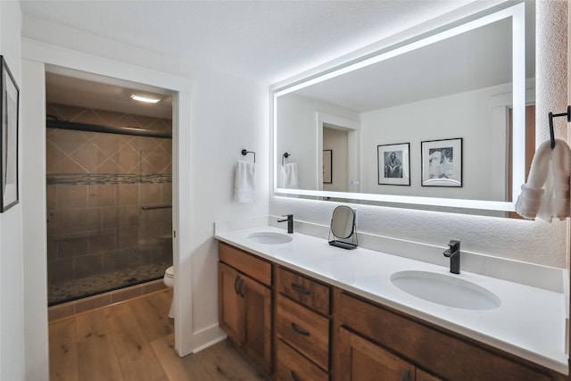 bathroom with a sink, a shower stall, and toilet