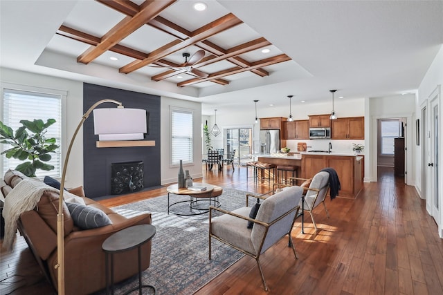 living room with baseboards, coffered ceiling, dark wood-style floors, beamed ceiling, and a fireplace