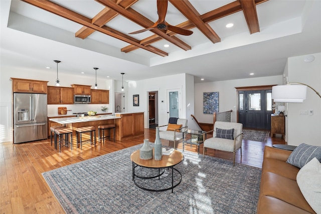 living room featuring recessed lighting, a ceiling fan, light wood-type flooring, coffered ceiling, and beamed ceiling