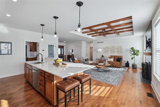 kitchen with coffered ceiling, a sink, visible vents, light wood-type flooring, and dishwasher