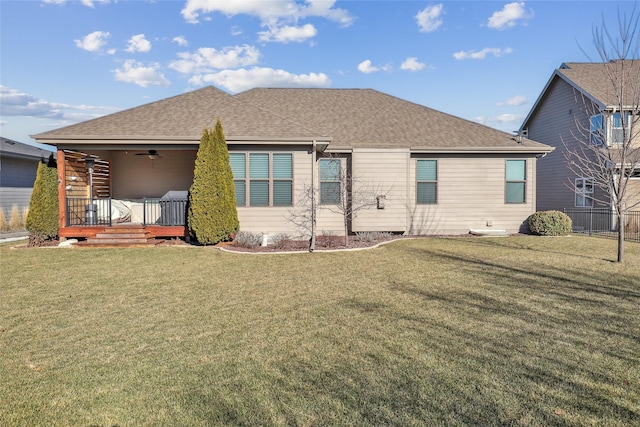 back of house featuring a shingled roof, a lawn, and ceiling fan