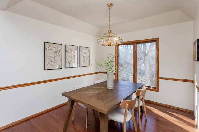 dining room featuring a notable chandelier, baseboards, and wood finished floors