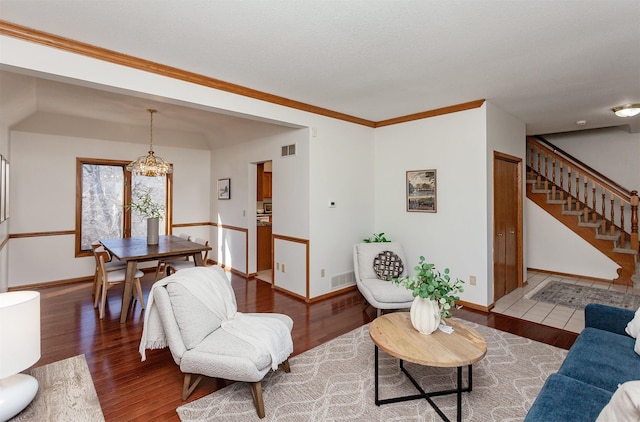 living area featuring stairs, visible vents, and wood finished floors