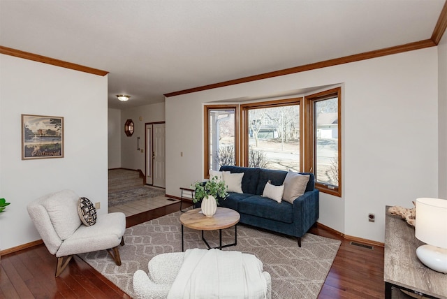 living area featuring wood-type flooring, visible vents, baseboards, and ornamental molding