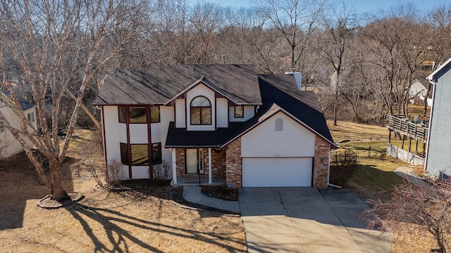 view of front of house featuring a garage, concrete driveway, brick siding, and fence