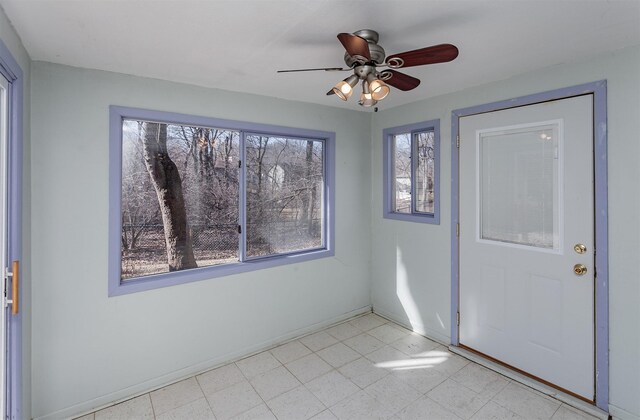 empty room featuring light floors, baseboards, and ceiling fan