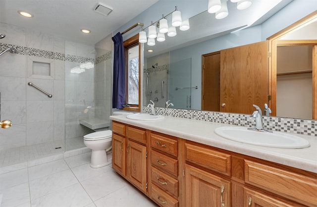 full bath featuring a stall shower, a sink, toilet, and double vanity