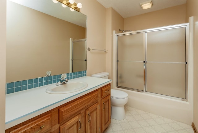 bathroom featuring shower / bath combination with glass door, vanity, toilet, and tile patterned floors