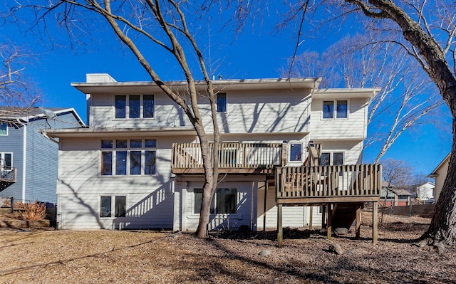 rear view of house with a wooden deck and a chimney