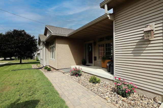 view of side of property with a lawn and roof with shingles