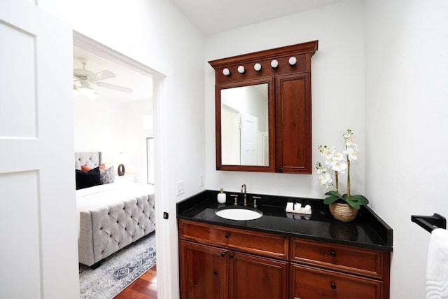 bathroom featuring wood finished floors, ceiling fan, vanity, and ensuite bathroom