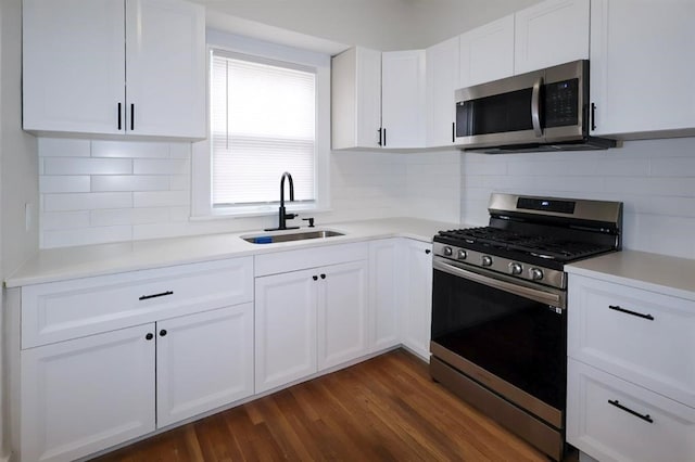 kitchen with stainless steel appliances, light countertops, dark wood-type flooring, white cabinets, and a sink