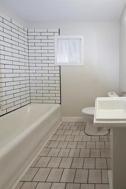 bathroom with tile patterned flooring, toilet, and baseboards