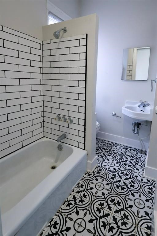 bathroom with baseboards, toilet, and tile patterned floors