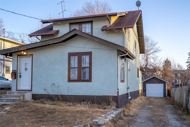 view of front of property with an outbuilding, entry steps, a garage, driveway, and stucco siding