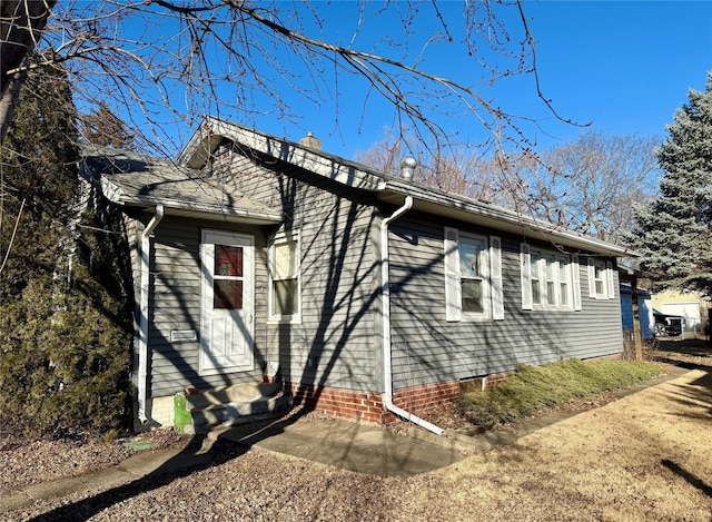 view of home's exterior featuring a chimney and entry steps