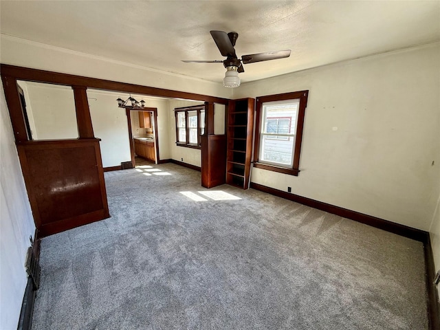 spare room with ornamental molding, carpet, baseboards, and ceiling fan