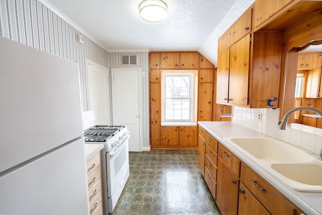 kitchen with white appliances, visible vents, light countertops, and a sink